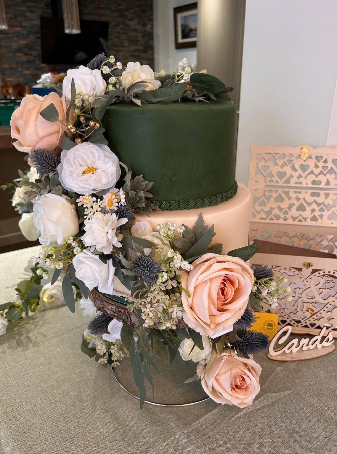 Elegant two tiered Scottish themed Wedding Cake Two tiered Scottish themed wedding cake with olive green & cream fondant, with cascades of white & peach roses and dusky green thistles.