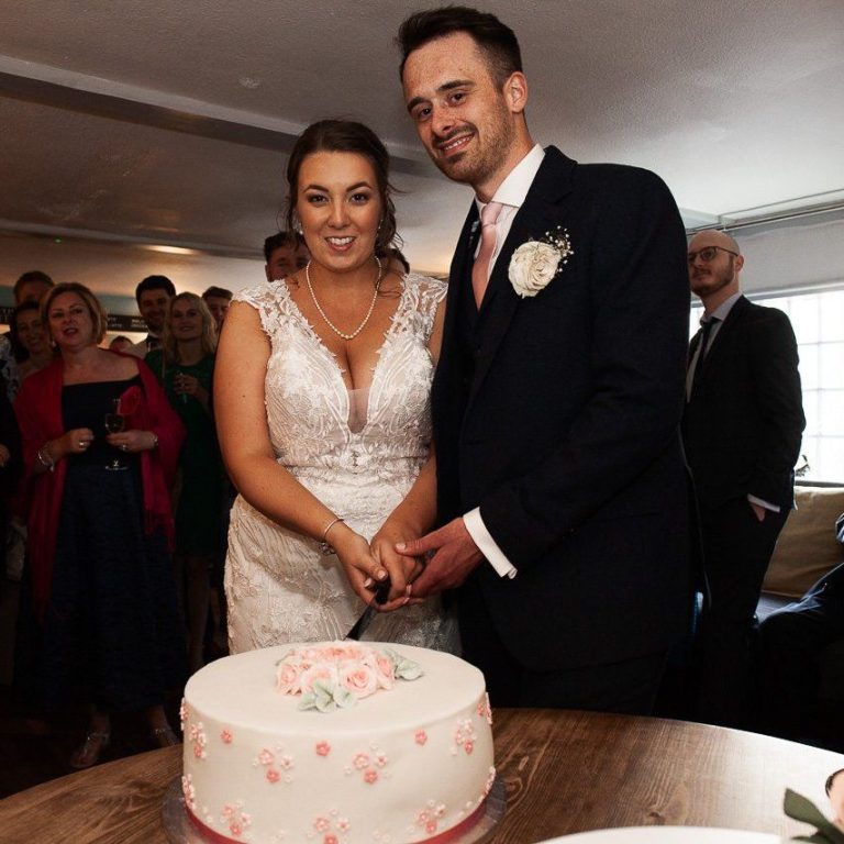 Happy wedding couple cutting wedding cake