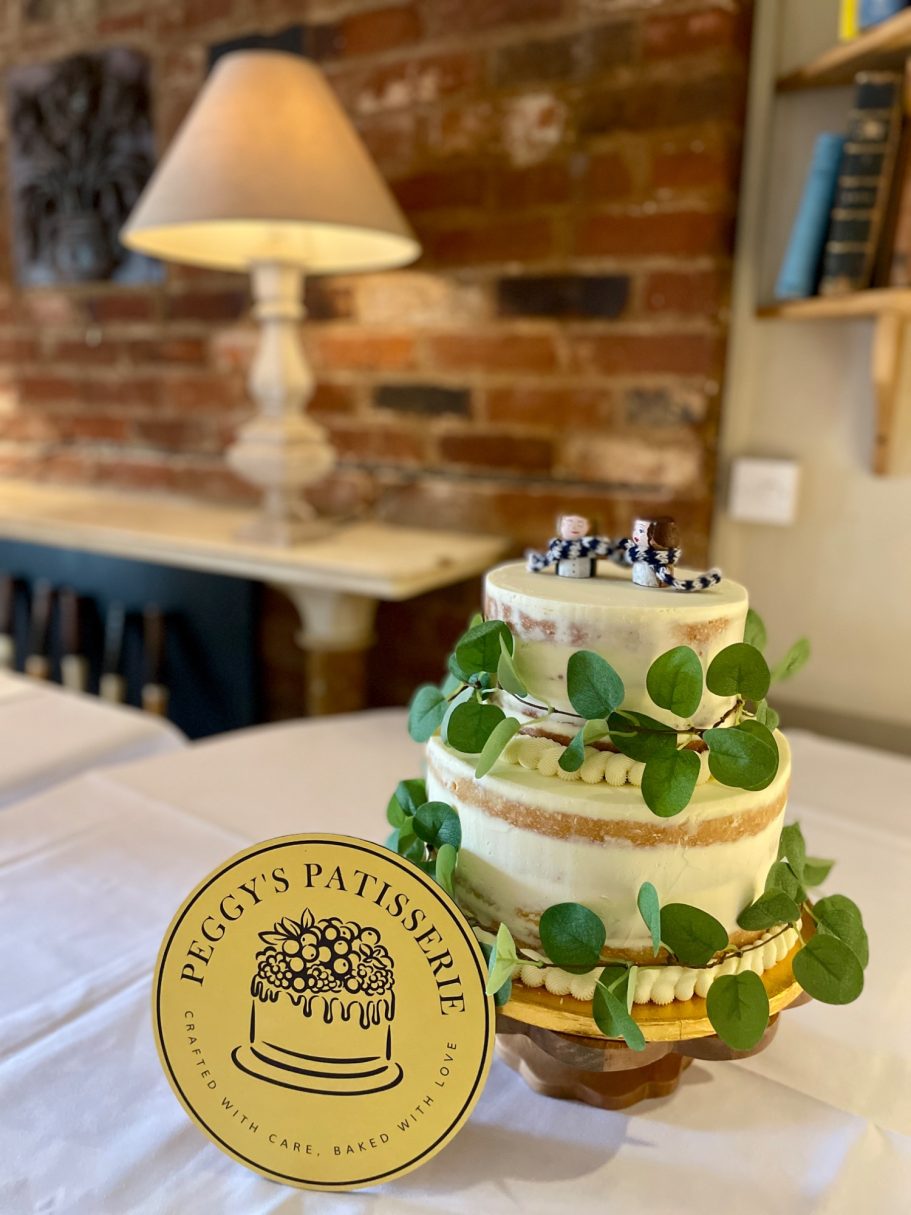 Semi-naked two tier wedding cake A two tier semi-naked wedding cake decorated with eucalyptus leaves