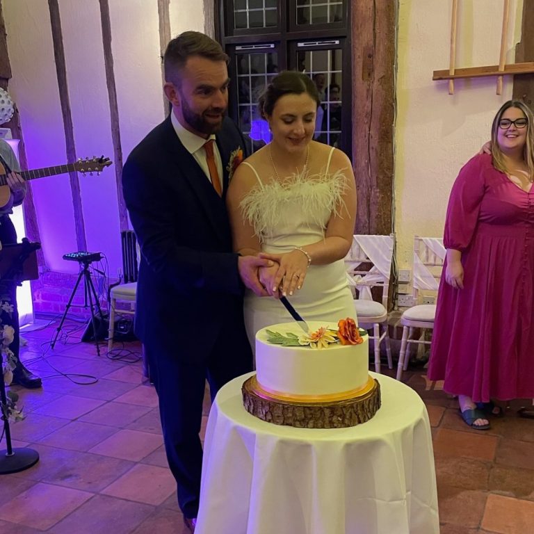 Happy wedding couple cutting wedding cake